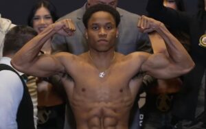 Boxer Floyd “Kid Austin” Schofield Jr. flexes muscles after weigh in