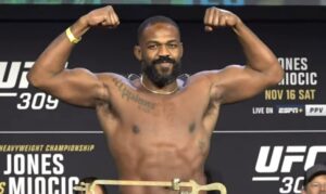 Jon Jones flexes muscles at UFC 309 weigh in